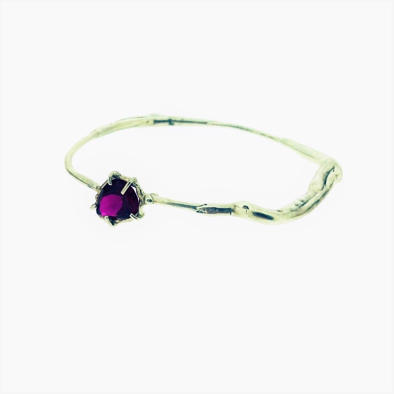 Full view of ruby shea bangle on white background.