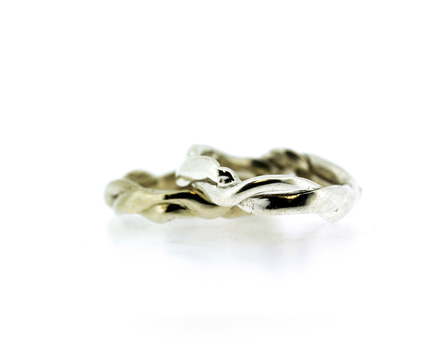 Full view of gold and silver Men's Current Bands stacked on top of one another.