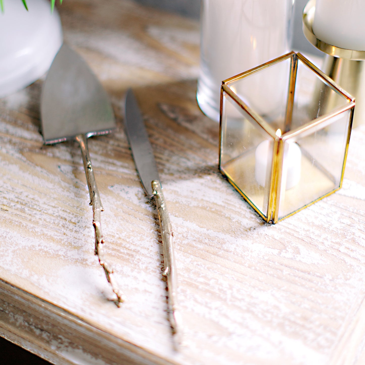 Handmade Sterling and Brass Cake Servers with Branch Handles and Hammered Texture on tabletop decorated for a wedding.