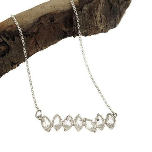 Close up view of pendant on White Topaz Cherin Necklace. Seven Sparkling natural marquise shaped White Topaz stones delicately adorn this irregular line-style bar necklace with subtle organic detailing.
