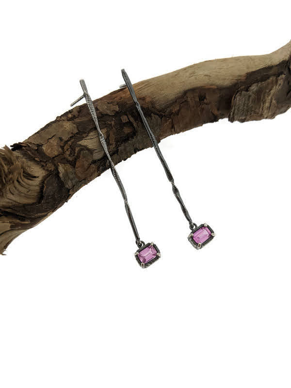 Full view of Pink Sapphire Gina Dangle Earrings laying on top of a stick.