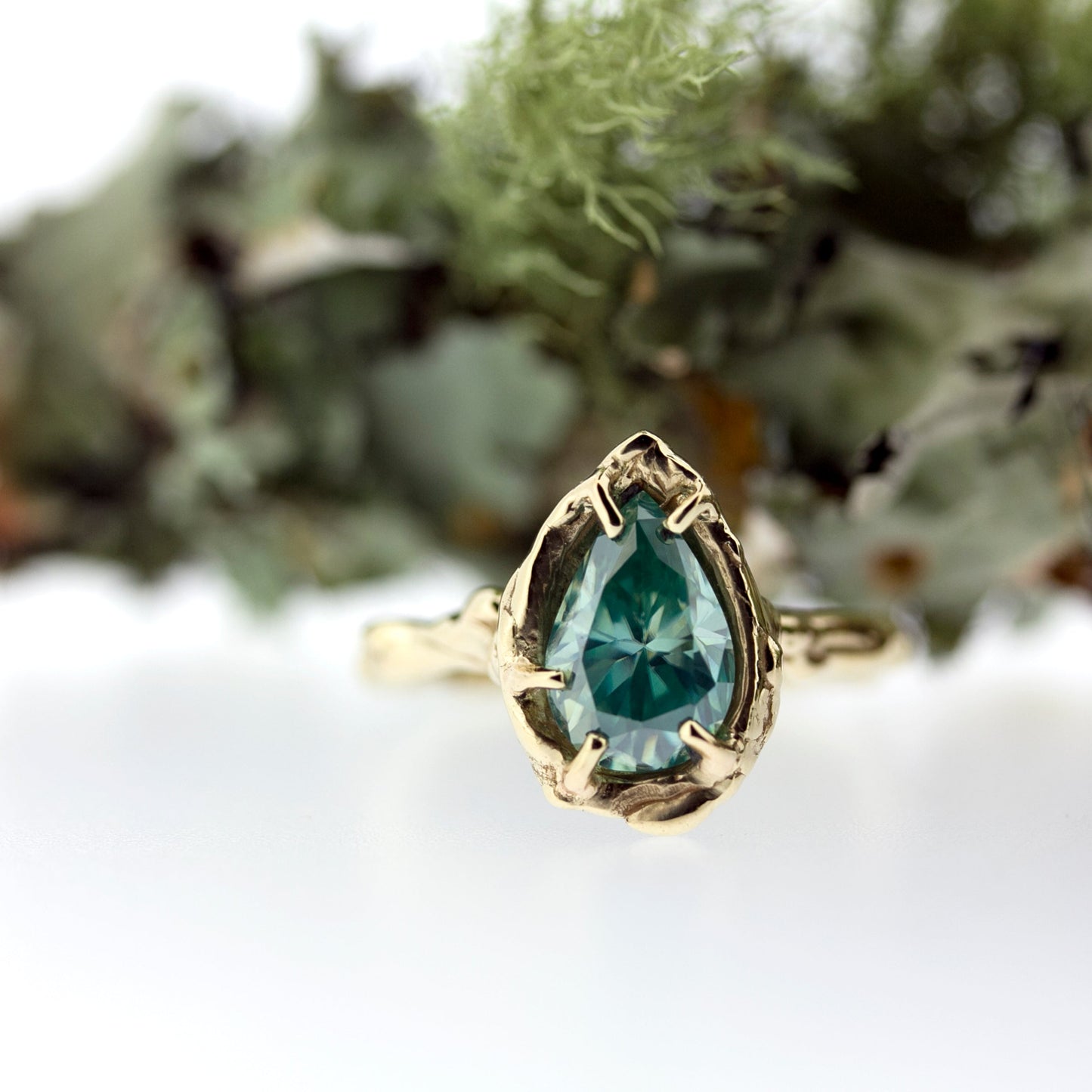 Full view of Nessa Ring with moss in background.