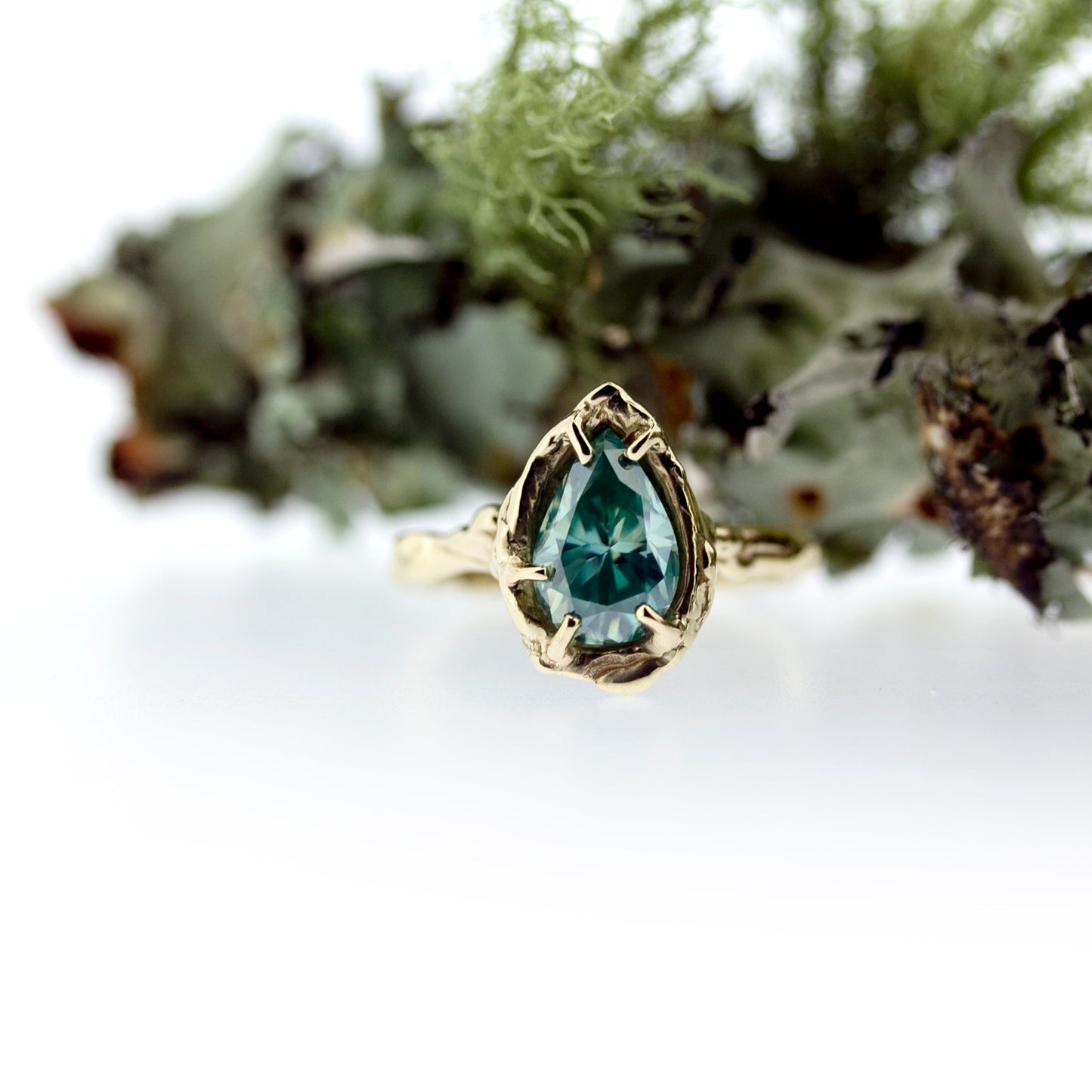 Full view of Nessa Ring with moss in background.