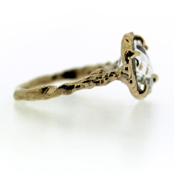 Side view of an organic inspired ring made in 14k yellow gold and trillion-shaped white topaz