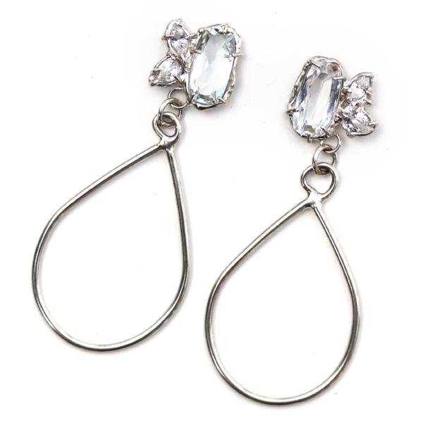 Sterling silver dangle earrings with three white topaz gemstone in various shapes and a tear drop shaped dangle.