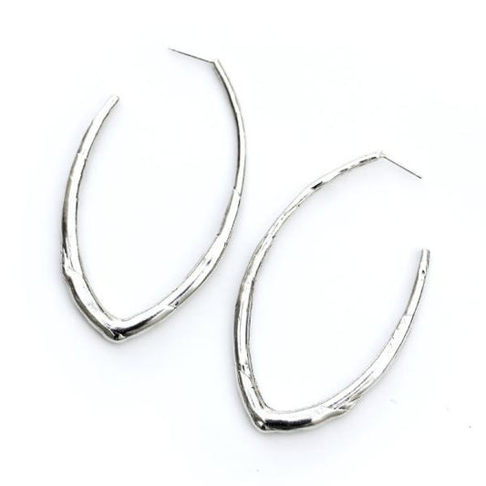 A sterling silver elongated hoop earring featuring an organic texture like a twig.