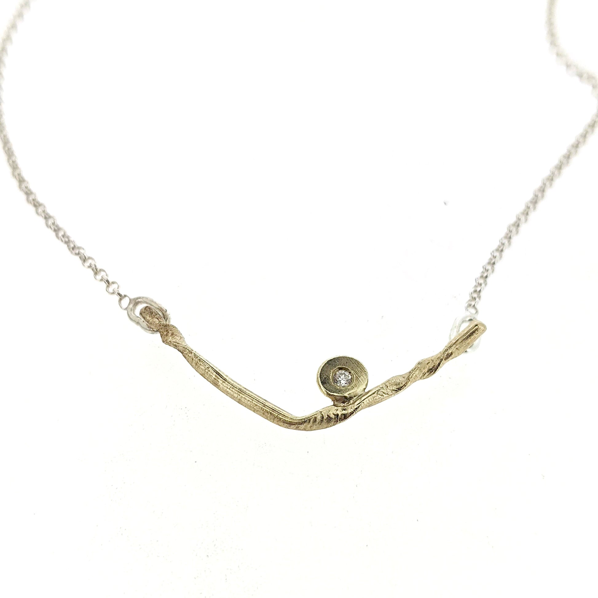 Close up view of pendant on Kate necklace. A sweet V-style necklace in yellow gold accented with one sparkling diamond.