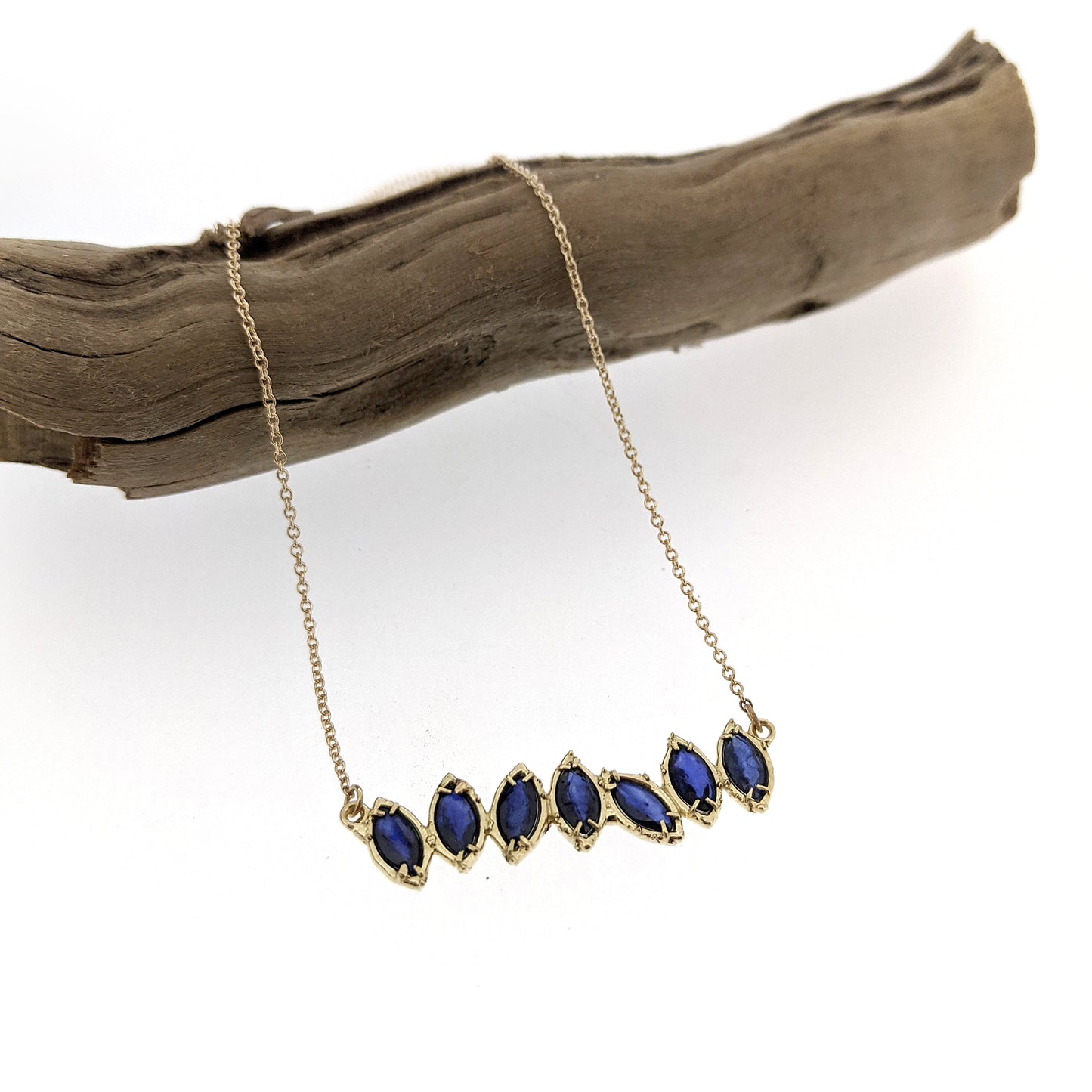 Full view of Sapphire Cherin Necklace draped over stick.