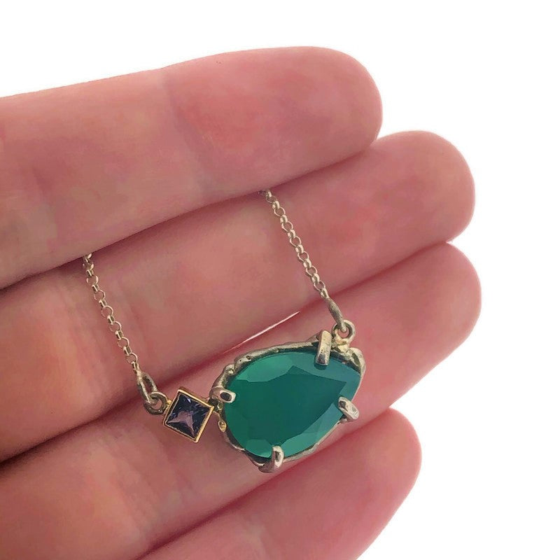 Detail shot of pendant on Green Onyx and Tanzanite Pendant with hand in background to help give an idea of its scale.