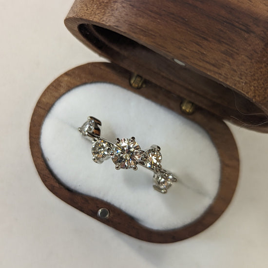 Diamond earring in a wooden jewelry box on a white background