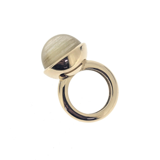 Gold ring with a highly domed rutilated quartz element on a white background