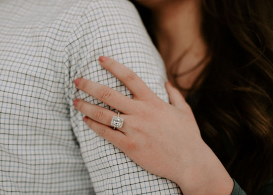 Close-up of a hand with an engagement ring on a checkered shirt
