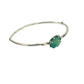 Full view of opaque emerald shea bangle on white background.