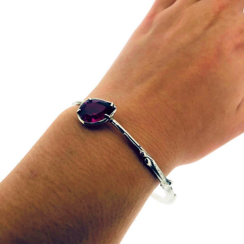 Full view of ruby shea bangle on woman's wrist to help give an idea of its scale.