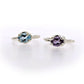 Frontal view of Blue Topaz and Amethyst Ada Rings sitting next to one another.