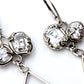 Detail of sterling silver dangle earrings with organic prong set white topaz gemstones.