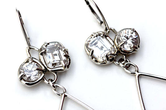 Detail of sterling silver dangle earrings with organic prong set white topaz gemstones.