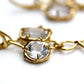 Detail photo of prong set white topaz gemstones in an organic looking earring.