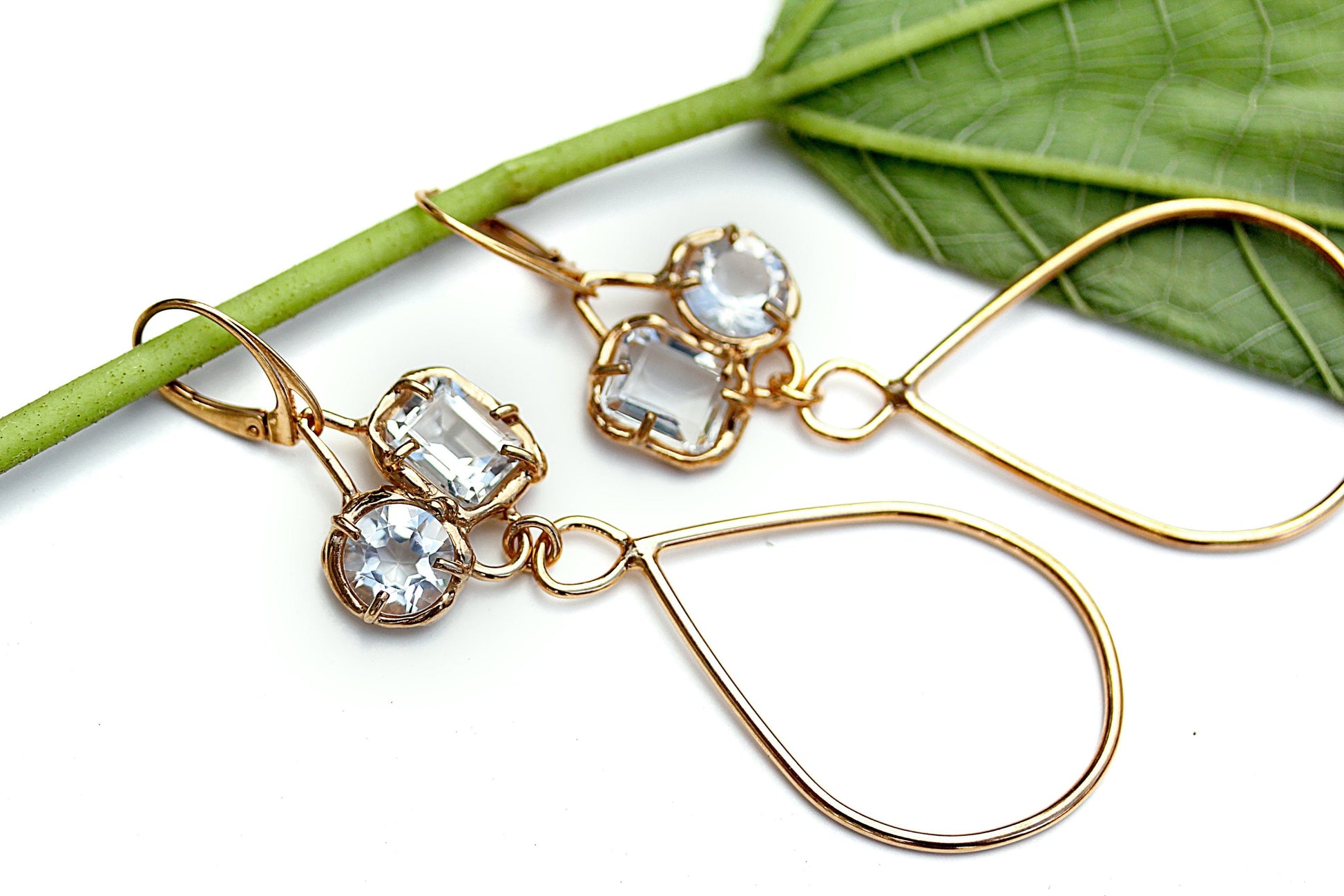 Organic style gold earrings with prong set White topaz gemstones and long tear drop shaped dangles.