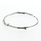 A sterling silver bangle bracelet that have a smooth organic texture that looks as if they are twigs covered in ice.