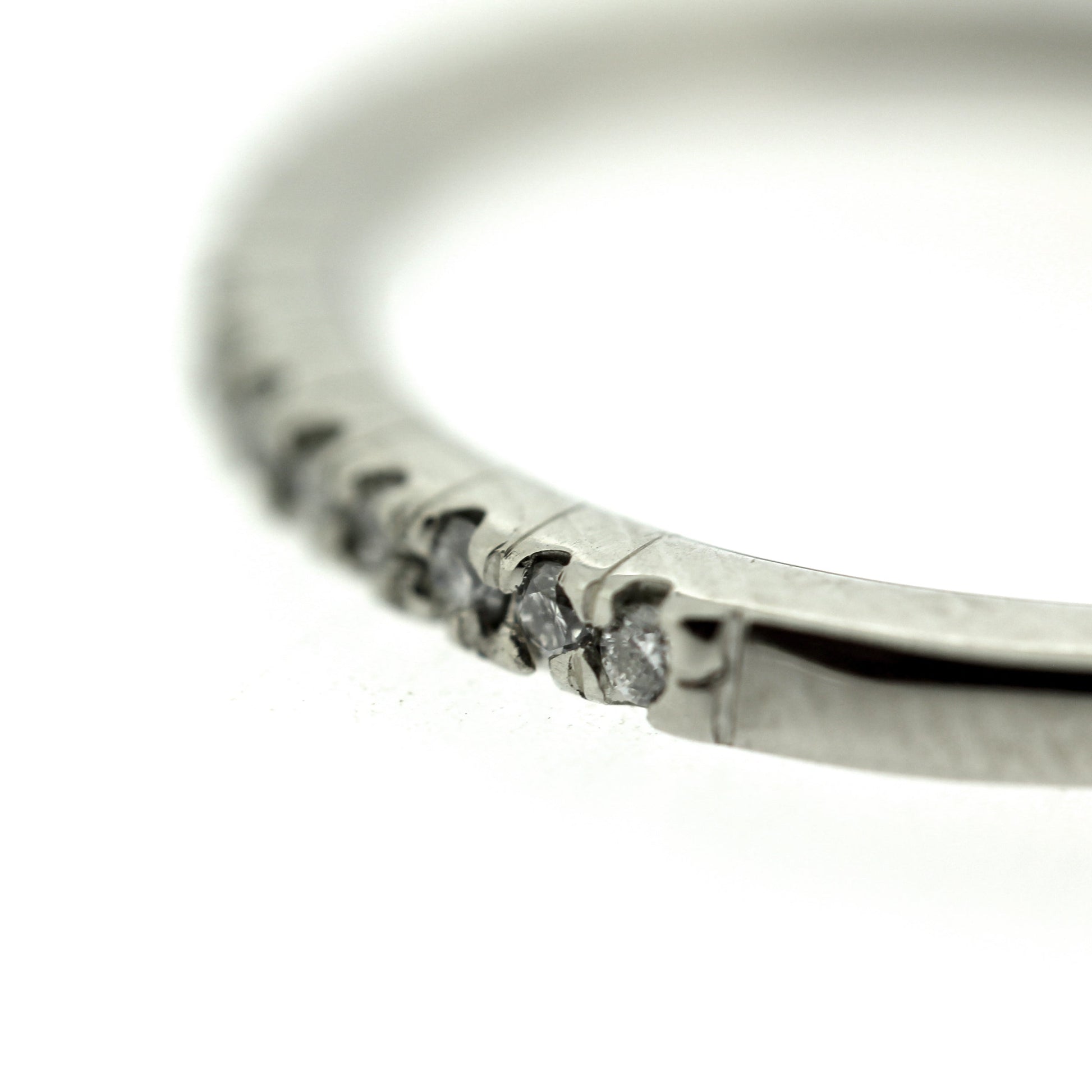 Detail view of diamonds on Erin Band. This band has set diamond going halfway around its band all set in white gold.