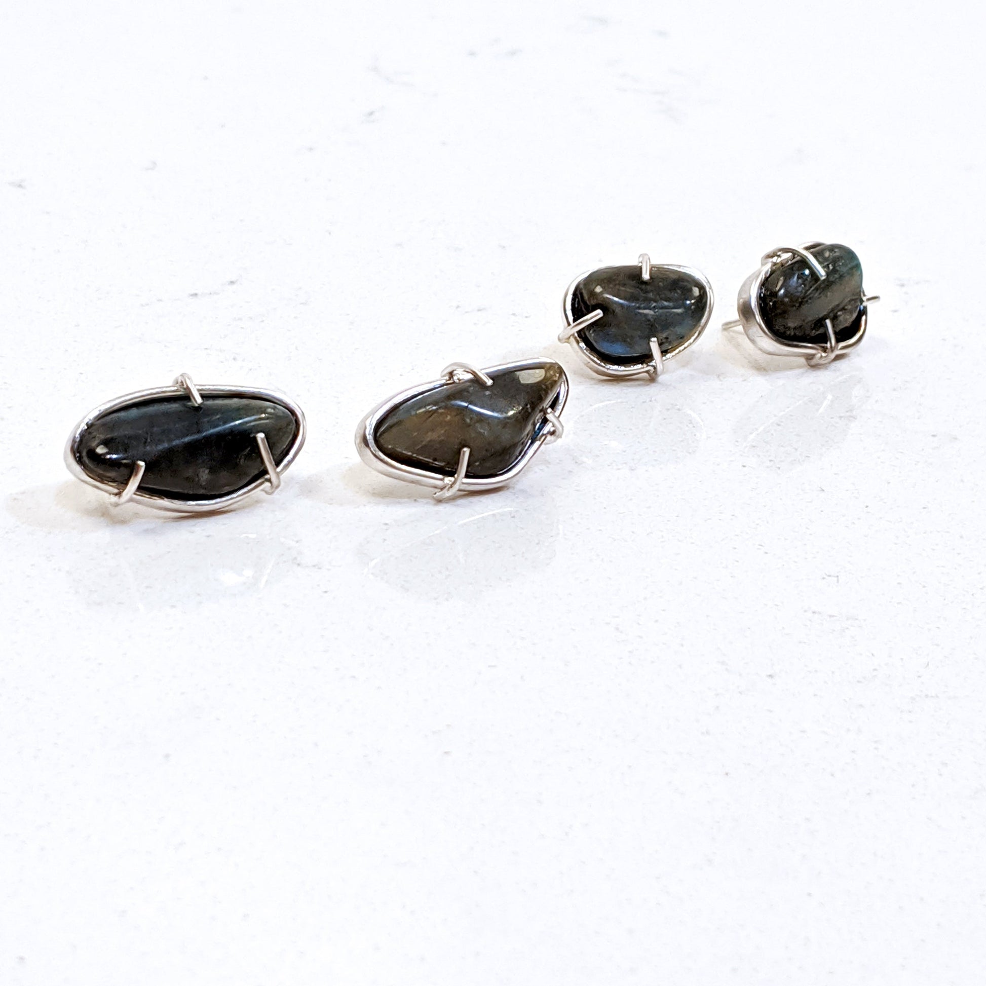 Full view of large and small Cassius Studs on white background.
