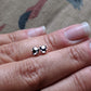 Full view of Black Diamond Stud Earring in-between two fingers to help give an idea of its scale.