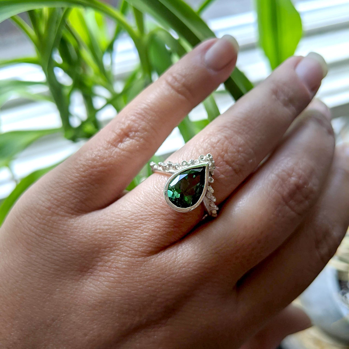 Full view of Gina Ring on woman's hand to help give an idea of its scale. A bright, bold Quartz is nestled amongst delicate texture references the spontaneous surfaces found in nature -- reminiscent of sea sponges or coral.  