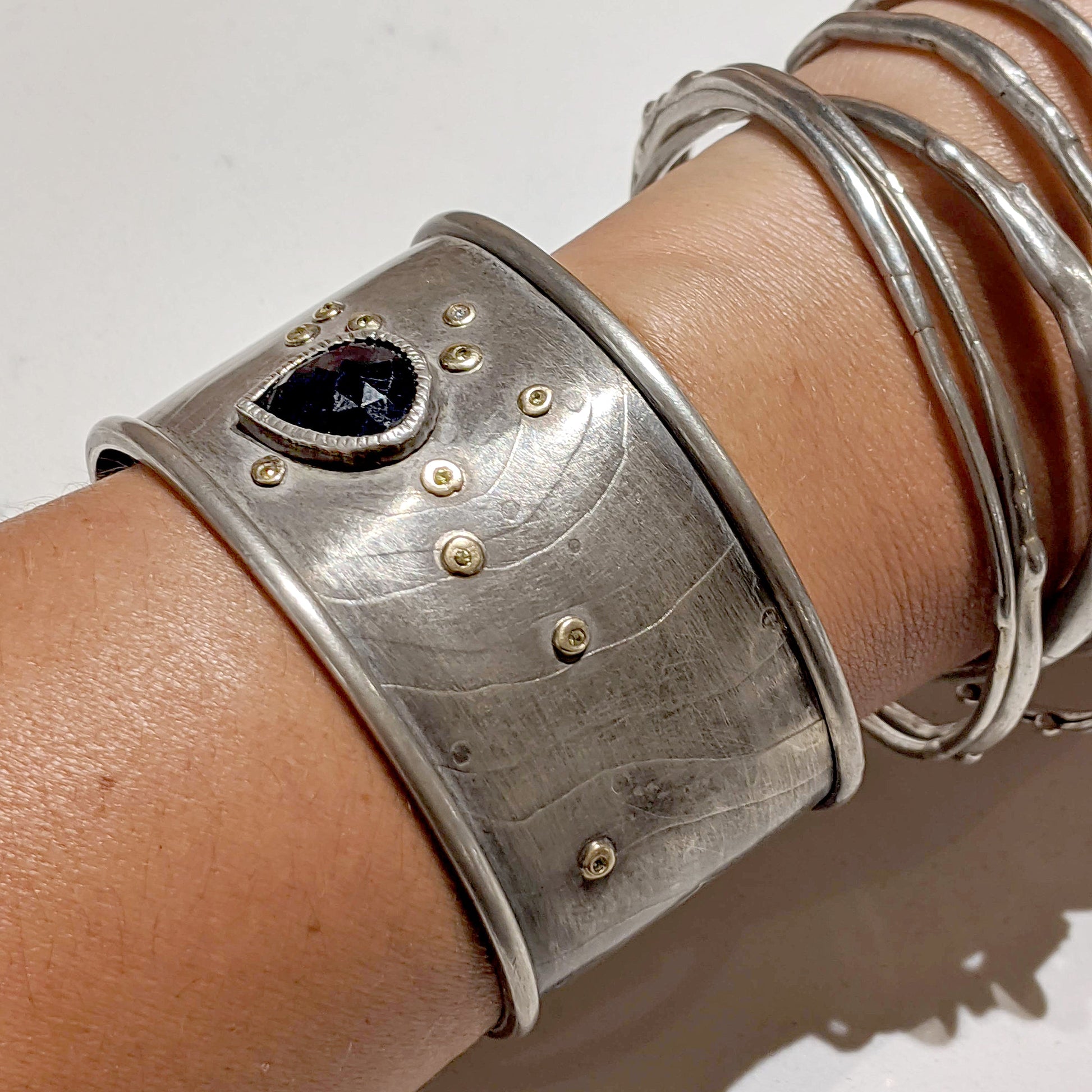 Full view of sapphire Cuff Bracelet on a woman's wrist to help give an idea of its scale.