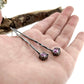 Full view of Pink Sapphire Gina Dangle Earrings laying on a woman's hand to help give an idea of their scale.