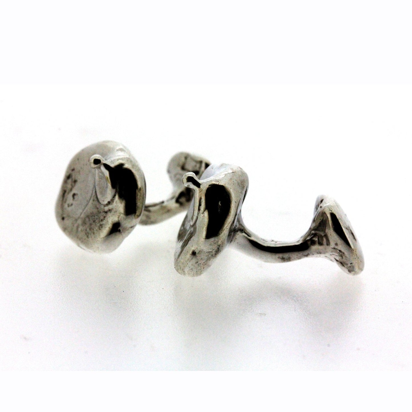 Full view of side of Henry Cufflinks. Designed, hand carved and cast by hand, the surface and form of these cufflinks have a fluid nature: an attempt to capture the ephemeral quality of moving water.  