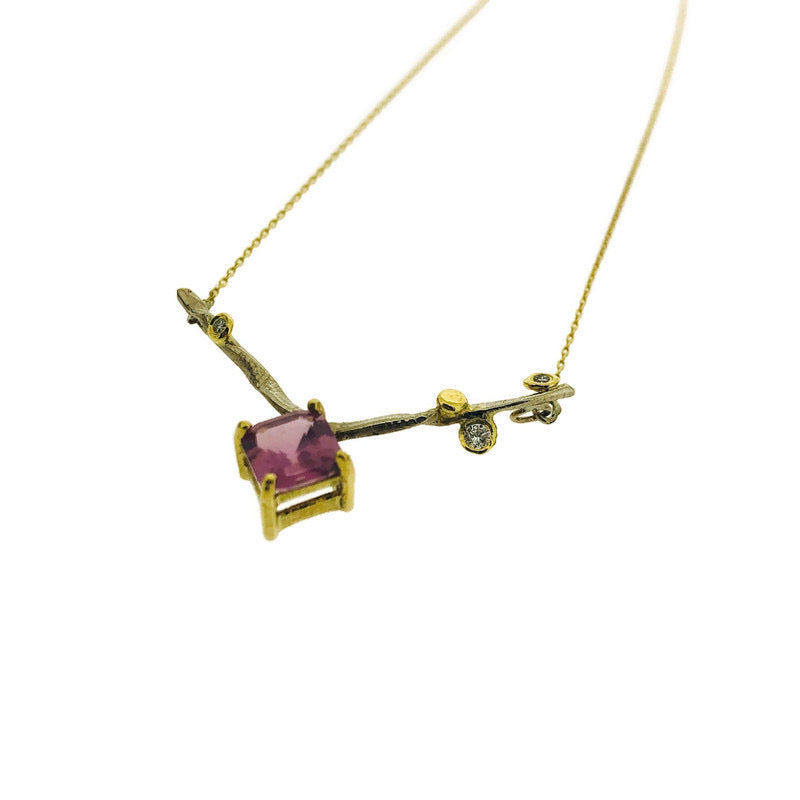 Angled view of pendant on Amelie necklace. In this image you can see more of the prongs and setting for the pink sapphire on the pendant.