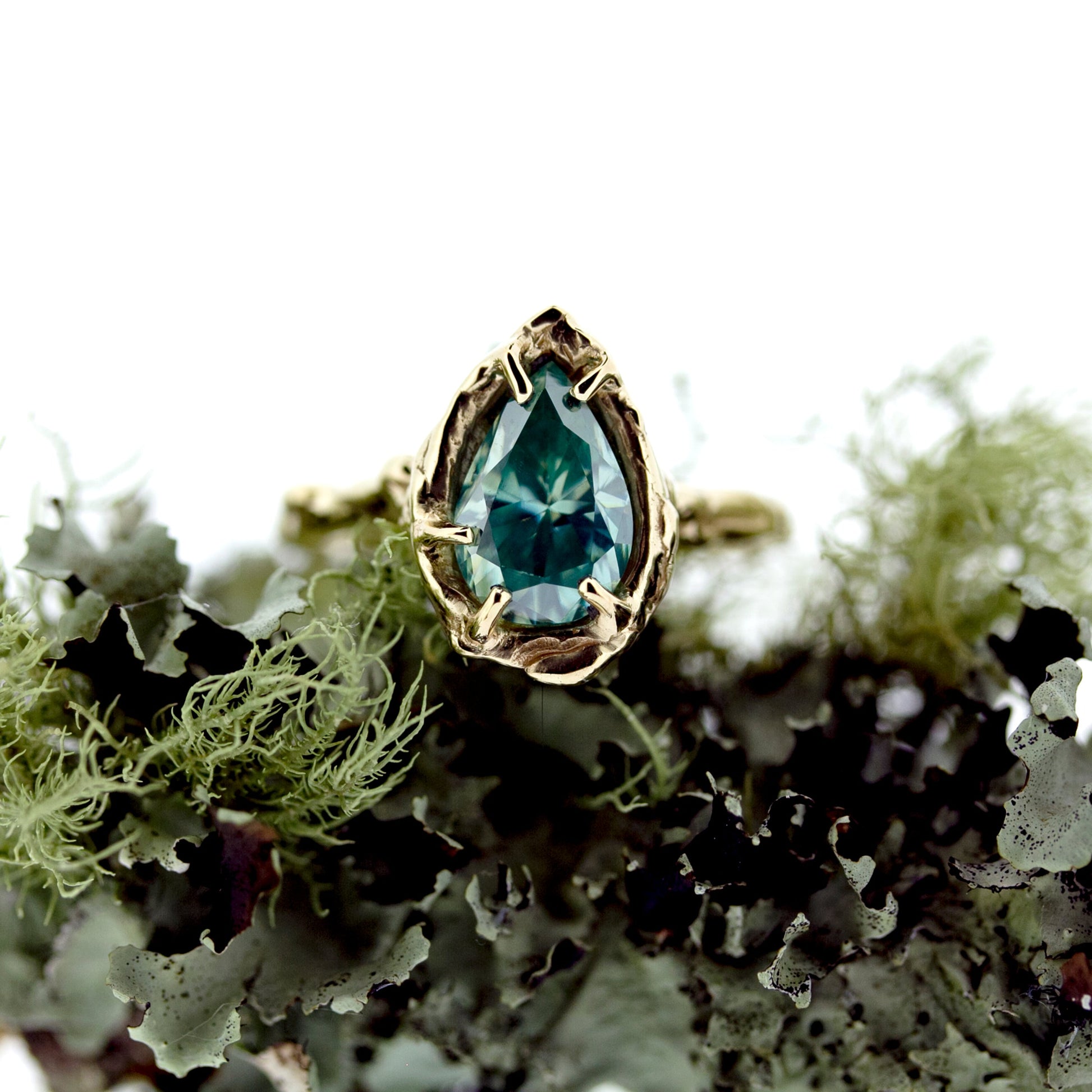 Full view of Nessa Ring with moss in background.