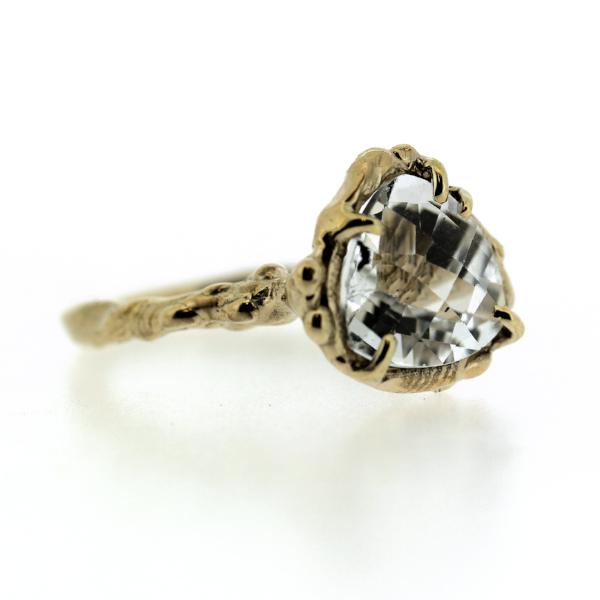 Side view of an organic inspired ring made in 14k yellow gold and trillion-shaped white topaz