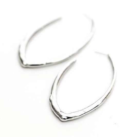 A sterling silver oval-shaped hoop earring featuring an organic texture.