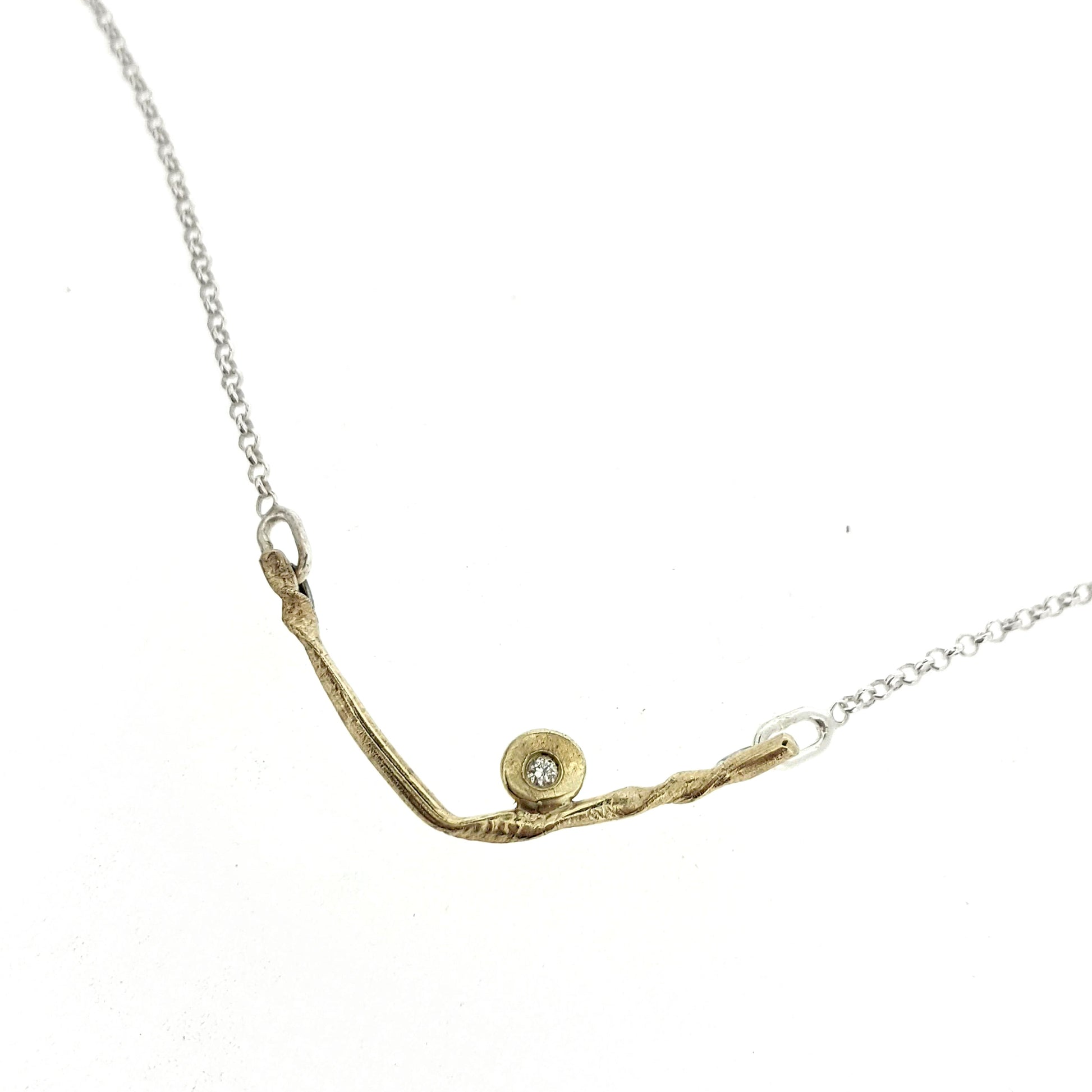 Close up view of pendant on Kate necklace. A sweet V-style necklace in yellow gold accented with one sparkling diamond.