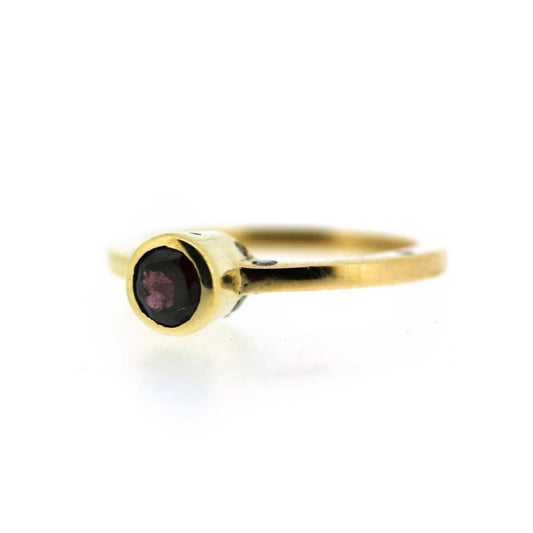 Full view of Luca Ring. This moody Garnet sparkles subtly in it's deep blood red color, surrounded by a surprise cluster of orgnically scattered Diamonds flush set along the bezel and band. 