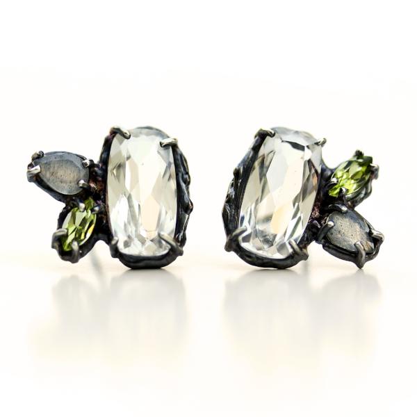 Slightly asymmetric stud earrings with white topaz, peridot and labradorite clustered together in an organic blackened sterling silver setting.