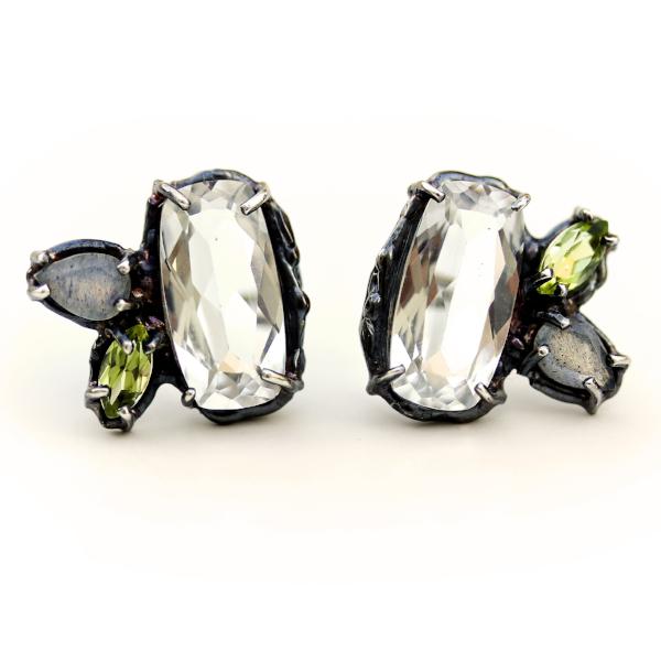 Slightly asymmetric stud earrings with white topaz, peridot and labradorite clustered together in an organic blackened sterling silver setting.