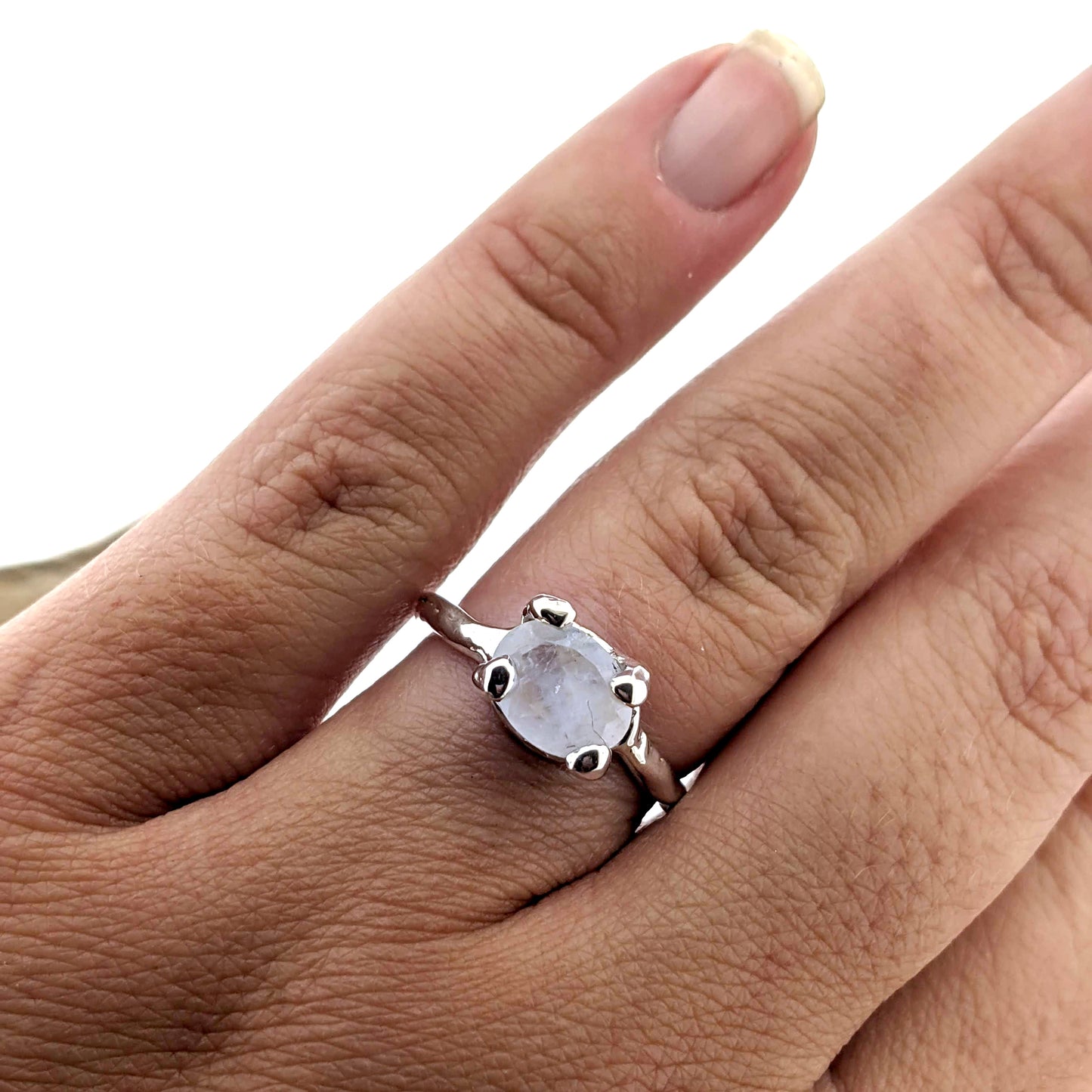 organic design rainbow moonstone and sterling silver solitaire ring, shown displayed on hand.