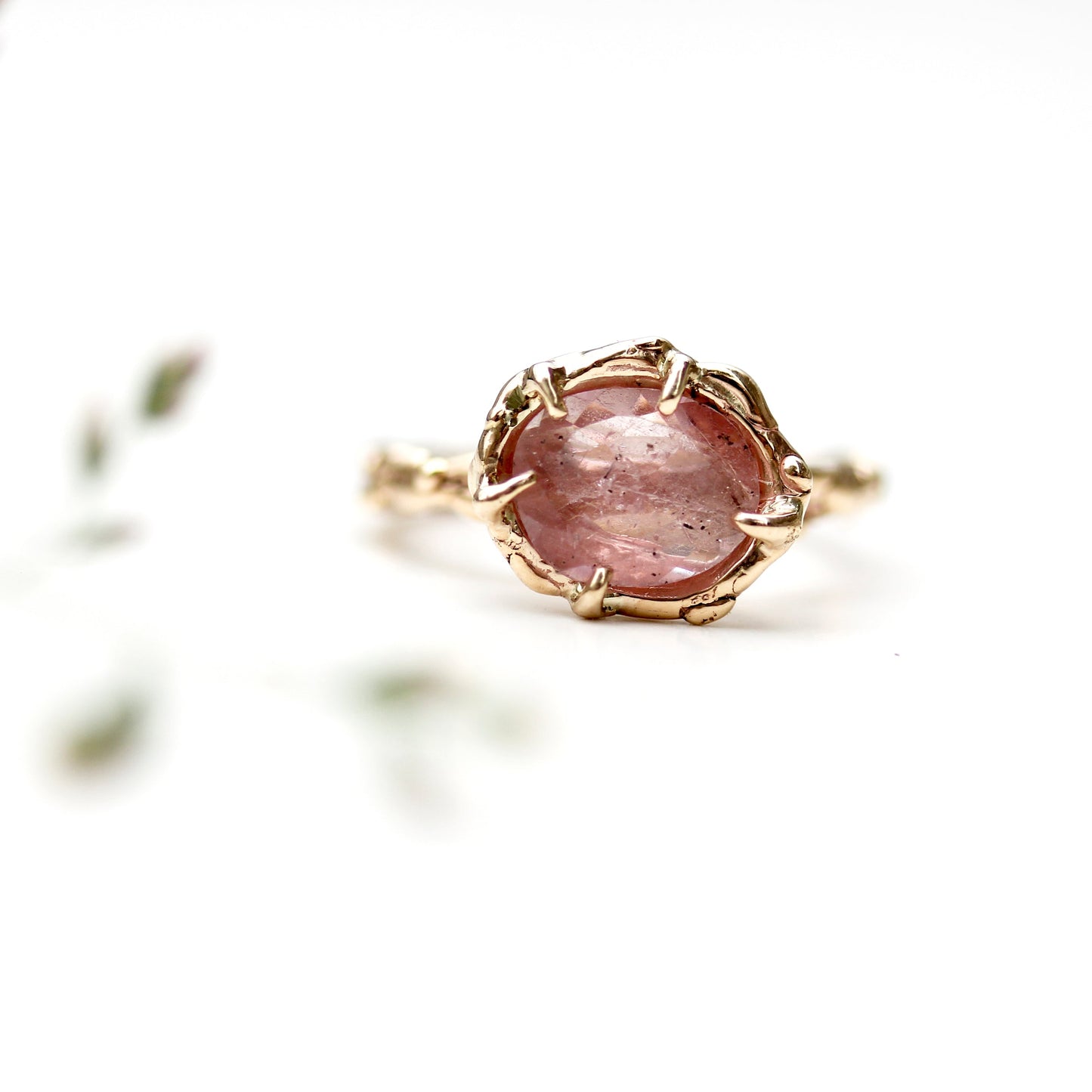 Full view of Roxanna Ring - medium. The Roxanna features organic carved metalwork with a delicately dappled surface.     A large 1.4 asymmetrical shaped Umba Sapphire in a beautiful shade of pale pink is set in 14K (recycled) Yellow Gold.