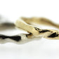 Close up view of silver and gold Surge Bands stacked on top of one another.