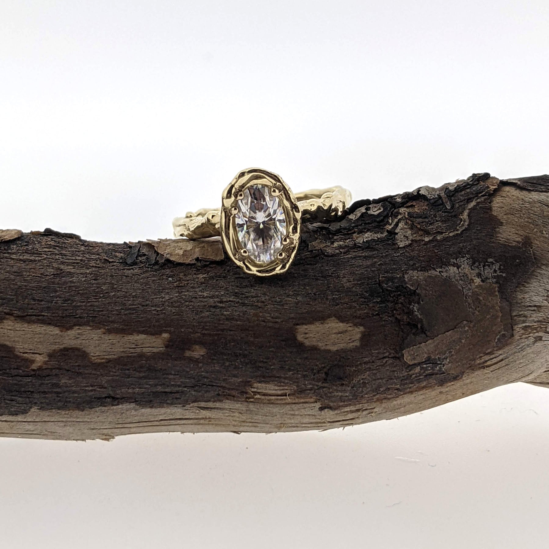 Full view of Annette Mooissanite Ring laying on stick.