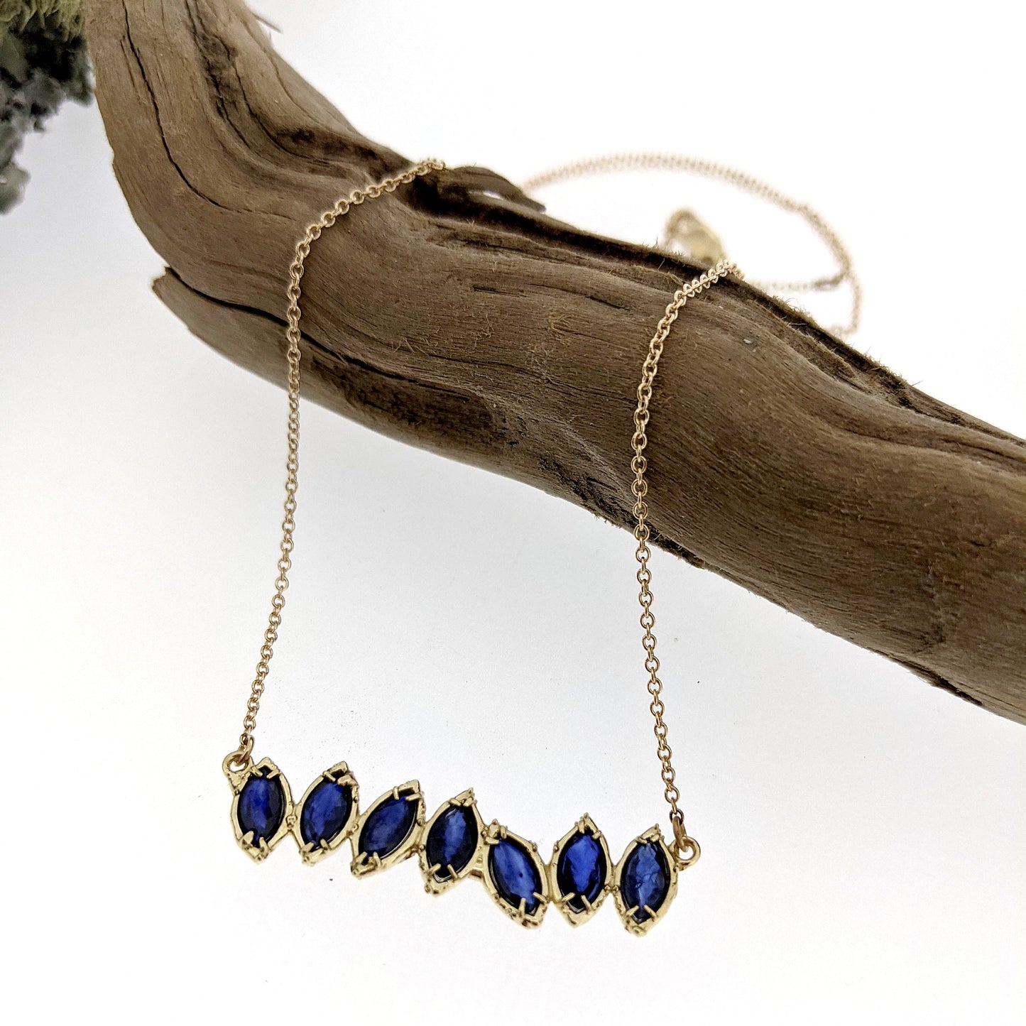 Full view of Sapphire Cherin necklace draped over stick.