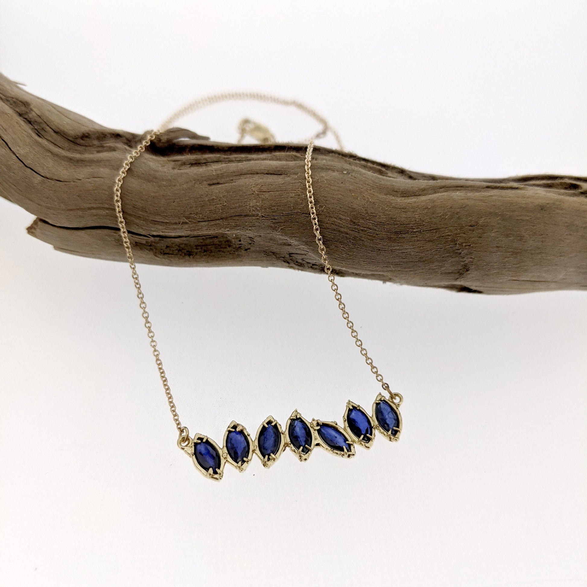 Full view of Sapphire Cherin Necklace draped over stick.