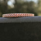 close up view on railing of rose gold and diamond wedding band