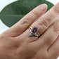 botanical leaf design nature inspired arched V shadow band wedding band , shown with purple color shift sapphire engagement ring