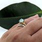 botanical leaf design nature inspired arched V shadow band wedding band , shown with teal oval moissanite engagement ring