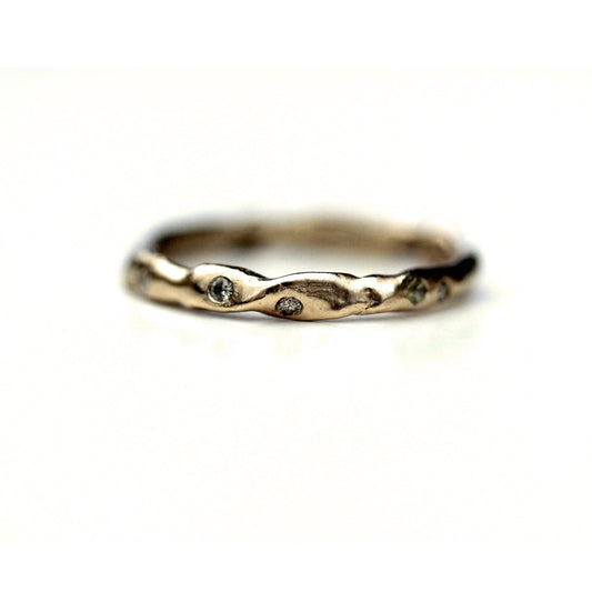 unique wedding band with flush set diamonds scattered along irregular band; view features twist texture on band